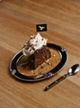 Date pudding with cream and a small falcon flag
