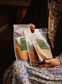Clear pouches of ground coffee with a green label