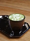 A matcha latte in a dark cup