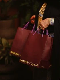 A burgundy gift bag with the gold Shalwa mark