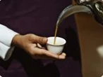 A guest barista serving a small cup