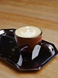 A flat white on a black tray