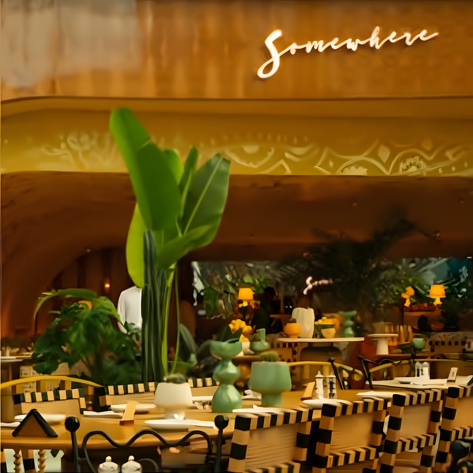 Somewhere dining room with palms under the script sign
